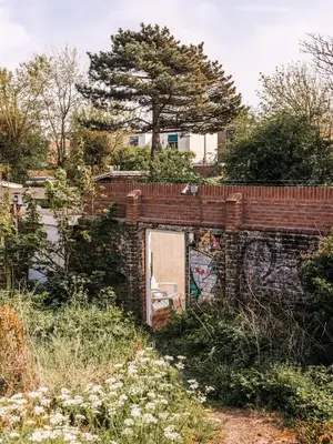 a brick wall with a door and a chair at Rosa's Cottage, garden and free parking in Zandvoort