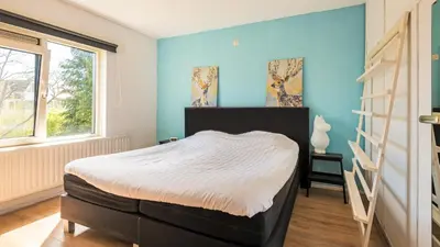 a bedroom with a bed and a blue wall at Casa Mimi in Bergen