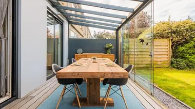 a dining room with a wooden table on a deck at Casa Mimi in Bergen