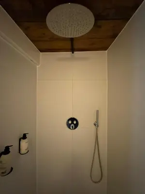 a bathroom with a clock on the wall at WS77 B&B Apartment in Leiden