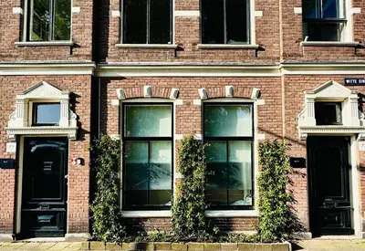 a brick building with windows and ivy on it at WS77 B&B Apartment in Leiden