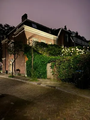 a brick house with a hedge in front of a street at WS77 B&B Apartment in Leiden