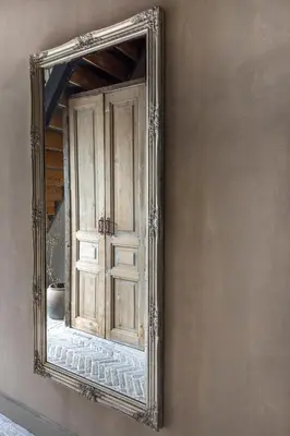 a mirror hanging on a wall with a door at Bed and Breakfast Lokaal Wadway in Spanbroek