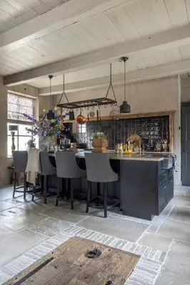 a kitchen with a table and chairs in a room at Bed and Breakfast Lokaal Wadway in Spanbroek