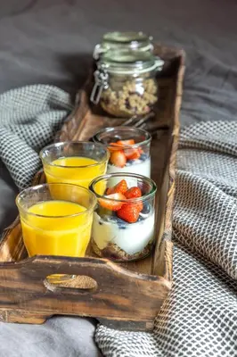 a tray of food with fruit and yogurt and orange juice at Bed and Breakfast Lokaal Wadway in Spanbroek