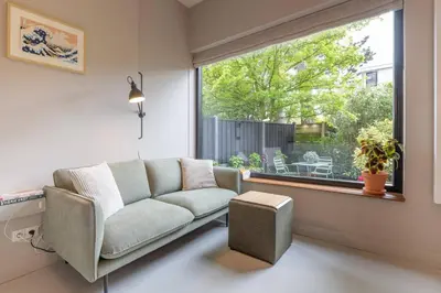 a living room with a couch and a window at Cosy Dutch Delight Apartment in Santpoort-Zuid