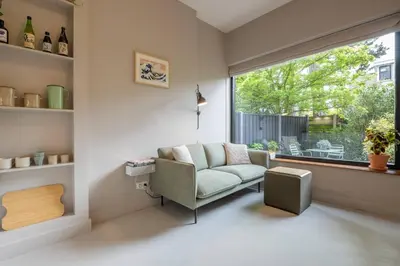 a living room with a couch and a window at Cosy Dutch Delight Apartment in Santpoort-Zuid