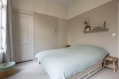 a white bedroom with a bed and a door at Cosy Dutch Delight Apartment in Santpoort-Zuid