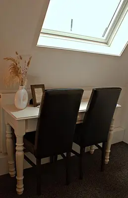 a dining room table with two chairs and a skylight at Het Wapen van Noordwijkerhout in Noordwijkerhout