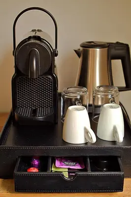 a black tray with a tea kettle and cups at Het Wapen van Noordwijkerhout in Noordwijkerhout