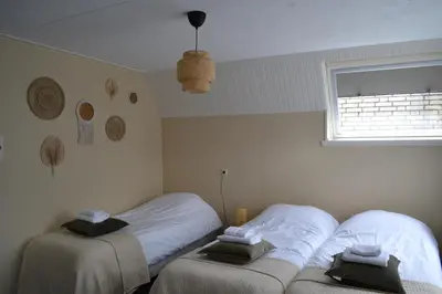 a bedroom with two beds with white sheets and a window at Het Wapen van Noordwijkerhout in Noordwijkerhout