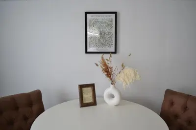 a white vase on a white table with two chairs at Het Wapen van Noordwijkerhout in Noordwijkerhout