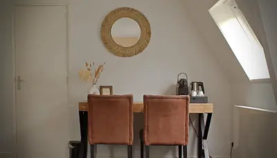 a dining room table with two chairs and a mirror at Het Wapen van Noordwijkerhout in Noordwijkerhout