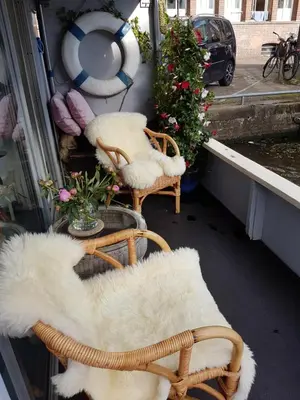 a balcony with two chairs covered in white fur at Pantheos Top Houseboat in Amsterdam