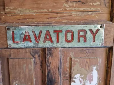 a sign on a wooden door with the word laundry at Pantheos Top Houseboat in Amsterdam