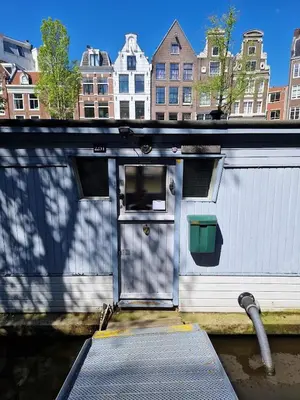 a white building with a door on the side at Pantheos Top Houseboat in Amsterdam