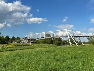 a white bridge over a field of grass at A tiny house - Amsterdam region in Lelystad