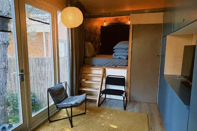 a tiny house with a desk and a chair at A tiny house - Amsterdam region in Lelystad