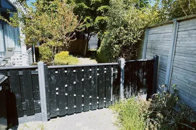 a black fence in front of a house at A tiny house - Amsterdam region in Lelystad