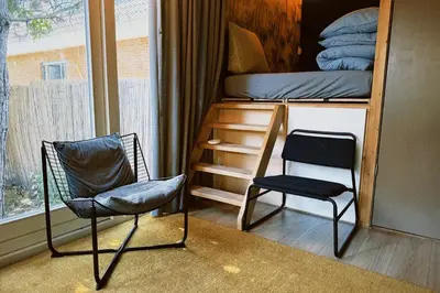 a room with two chairs and a bunk bed at A tiny house - Amsterdam region in Lelystad