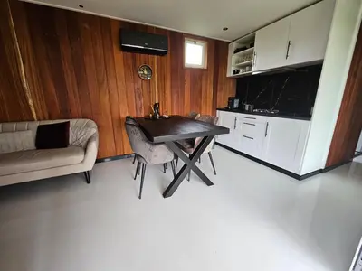 a kitchen with a table and a couch in a room at Ben's Cabine - De Hollandse Boerderij in Bodegraven