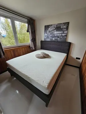 a large bed in a room with a window at Ben's Cabine - De Hollandse Boerderij in Bodegraven