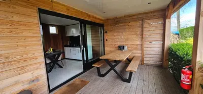 a wooden patio with a bench and a kitchen at Ben's Cabine - De Hollandse Boerderij in Bodegraven