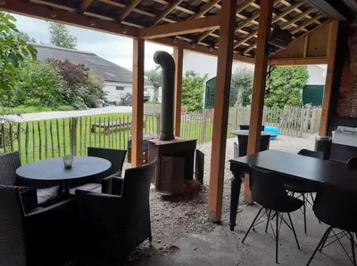a patio with tables and a wood stove at Riante Boerderij in Het Groene Hart Regio Utrecht in Oudewater