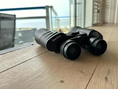 a pair of binoculars laying on a wooden floor at Sterflat aan Zee in Egmond aan Zee