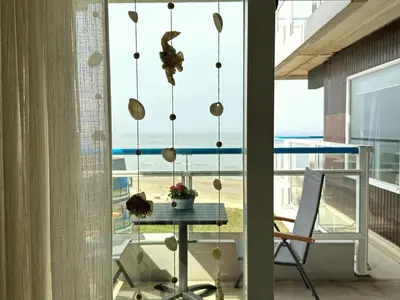 a room with a table and a view of the ocean at Sterflat aan Zee in Egmond aan Zee