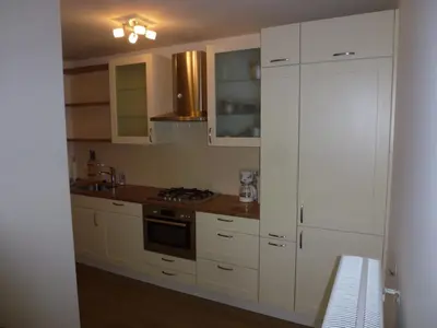 a kitchen with white cabinets and a stove top oven at Schiphol Apartments in Aalsmeer