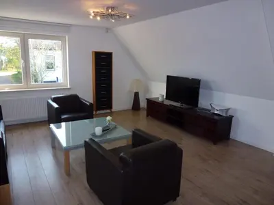 a living room with a couch and a tv at Schiphol Apartments in Aalsmeer