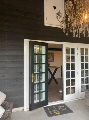 a chandelier is hanging above a door to a house at tuinhuis in Harmelen
