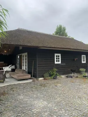 a small house with a couch and a patio at tuinhuis in Harmelen