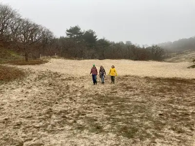 a group of three people walking in a field at Deborah's Hiding Place in Alkmaar