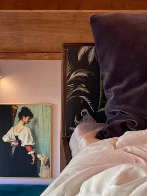a painting on the wall next to a bed at Deborah's Hiding Place in Alkmaar