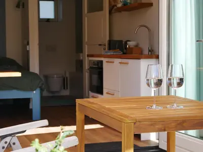 two wine glasses sitting on a wooden table in a kitchen at Zandkasteel Zandvoort in Zandvoort