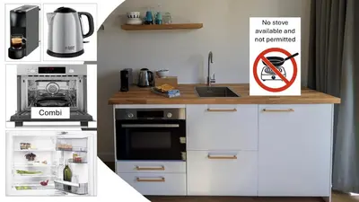 a kitchen with white cabinets and a no smoking sign at Zandkasteel Zandvoort in Zandvoort