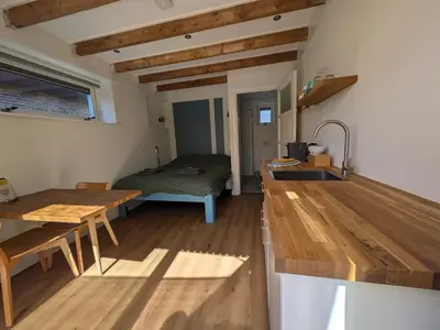 a kitchen with a table and a bed in a room at Zandkasteel Zandvoort in Zandvoort