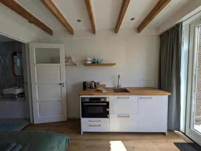 a kitchen with white cabinets and a counter top at Zandkasteel Zandvoort in Zandvoort
