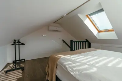 a attic bedroom with a bed and a skylight at Bos, duin en strand huisje in Noordwijk