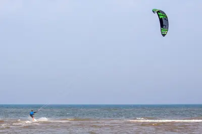 a man kite surfing in the ocean on the water at Bos, duin en strand huisje in Noordwijk