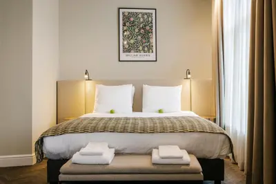 a bedroom with a large bed with two folded towels at Hotel Bloemendaal by BHC in Bloemendaal