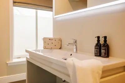 a bathroom with a sink and a mirror at Hotel Bloemendaal by BHC in Bloemendaal