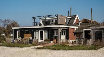 a black house with a balcony on top of it at B&B Hartenlust kamer de Bedstee in Bodegraven