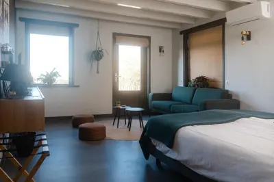 a bedroom with a bed and a couch and a table at B&B Hartenlust kamer de Boomgaard in Bodegraven