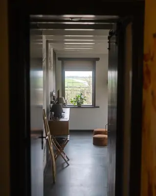an open door to a room with a desk and a window at B&B Hartenlust kamer de Boomgaard in Bodegraven