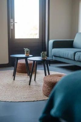 a living room with two tables and a couch at B&B Hartenlust kamer de Boomgaard in Bodegraven