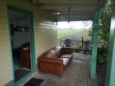 a leather couch sitting on a screened in porch at Sweet Tiny House in Westbeemster
