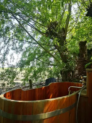 a wooden bath tub in front of a tree at Sweet Tiny House in Westbeemster